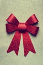 A beautiful big red bow on a silver glittering background.