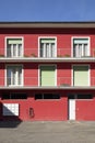 Detail of a red railing house with parking below. There is a letterbox for the entire condominium and a closed white door Royalty Free Stock Photo