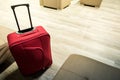 Detail of red suitcase in the airport waiting room. Lounge with lounge chairs Royalty Free Stock Photo