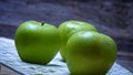 Detail on ripe green apples on wooden table