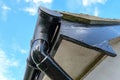 Detailed view of a newly painted drain and gutter seen on a house.