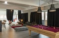 Detail of the room with a pool table, a sitting area with armchairs and sofas and a bar corner Royalty Free Stock Photo