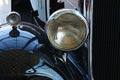 Detail of round front light and part of the fender and front mask of veteran car Packard Light Eight, produced in year 1932