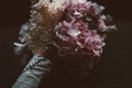 Detail of a rustic bridal bouquet on a dark background