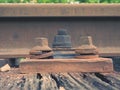 Detail of rusty screws and nut on old railroad track. Rooten wooden tie with rusty nuts and bolts. Royalty Free Stock Photo