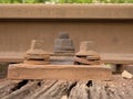 Detail of rusty screws and nut on old railroad track. Rooten wooden tie with rusty nuts and bolts. Royalty Free Stock Photo