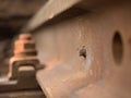 Detail of rusty screws and nut on old railroad track. Rotten wooden tie with rusty nuts and bolts. Royalty Free Stock Photo