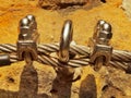 Detail of clamp at end of irone rope. Climbers iron twisted rope fixed in block by screws snap hooks anchored into rock. Royalty Free Stock Photo