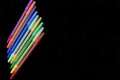 Set of pens of different colors on black background.