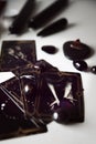 Detail of several black tarot cards with black candles and black stones