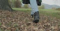 Detail on shoes and steps. Caucasian blond woman slomo walking toward fall woods touching tree. Following behind gimbal