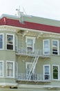 Detail shot of building facade on appartment building with red roof tiles and beige paint with white fire escape ladder