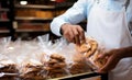 Detail shot Man neatly packaging cookies into a plastic grocery bag Royalty Free Stock Photo