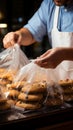 Detail shot Man neatly packaging cookies into a plastic grocery bag Royalty Free Stock Photo