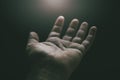 Detail shot of the palm of a man\'s hand facing upwards lit from above