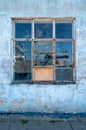 Detail shot of a window of a port warehouse with blue sky and boat reflecting in its square tiled window. Cracked and Royalty Free Stock Photo