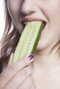 Detail shot of woman eating cucumber over white background Royalty Free Stock Photo