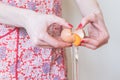 A detail shot of a woman's hands cracking an egg