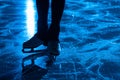 Detail shot of women legs in white figure skating skates on ice arena. Professional sportswoman trains on dark ice rink Royalty Free Stock Photo