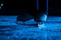 Detail shot of women legs in white figure skating skates on ice arena. Professional sportswoman trains on dark ice rink Royalty Free Stock Photo