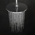 Detail of a shower head with modern dark tiles