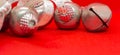 Detail of silver and white christmas balls and red bell on red background Royalty Free Stock Photo