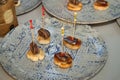 Detail of small slices of bread with an anchovy skewer and a mackerel skewer with caviar during a catering event. Concept food,