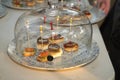 Detail of small slices of bread with an anchovy skewer, a mackerel skewer with caviar and a salmon and cheese skewer covered by a