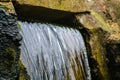 Detail of a small waterfall flowing down a stone wall in a park Royalty Free Stock Photo