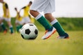 Detail soccer player kicking ball on field. Soccer players on training session