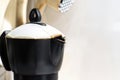 detail of the spout of the black coffee pot with the white lid in a domestic kitchen. Royalty Free Stock Photo