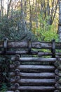 Detail of a stacked log support for a water sluice, autumn leaves and rhododendrons