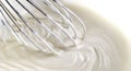 Detail of a stainless steel hand mixer with whipped cream