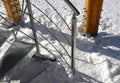 Detail of the stainless steel handrail mounting on the outdoor staircase of the terrace made of bent polished pipe. galvanized pri Royalty Free Stock Photo