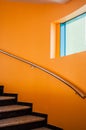 Curved staircase in a luxury office building next to an orange w Royalty Free Stock Photo