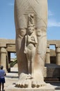 Detail of egyptian statue of Pharaoh Ramses II with small statue of Nefertari at his feet