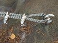 Detail of steel bolt anchor eye in rock. The end knot of steel rope. Climbers path in rocks via ferrata. Iron twisted rope fixed Royalty Free Stock Photo