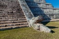 Detail of the steps and a serpent head sculpture of the pyramid Kukulkan in the Mayan archeological site Chichen Itza Royalty Free Stock Photo