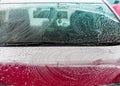 Detail on strokes of white soap foam on the windshield in car wash Royalty Free Stock Photo