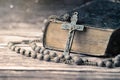 Detail studio shot of very old, vintage Holy Bible with lots of ornaments on the cover and yellow pages and old rosary