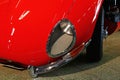 Detail of stylish headlight on opened trunk of red classical british sports car Jaguar E type