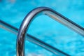 Detail of thermal swimming pool tiled stairs down water and metal handle