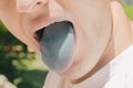 Detail of a tongue colored blue by the coloring of a candy that excites and inflames the salivary and lingual glands Royalty Free Stock Photo