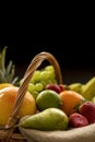 Detail from top on a basket full of fresh bio fruit on a dark backgrou Royalty Free Stock Photo