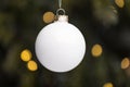 Detail of a traditional white Christmas flask hanging on a tree