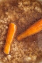 Detail on traditional hot beef roth with vegetable, top view of hot soup with carrot and pasta Royalty Free Stock Photo