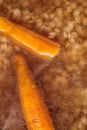 Detail on traditional hot beef roth with vegetable, top view of hot soup with carrot and pasta Royalty Free Stock Photo