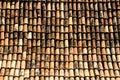 Detail from traditional old house roof with old brown ceramic tiles, damaged and worn out by exposure to the elements