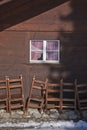 Detail of traditional wooden swiss house and group of wooden chairs outdoors