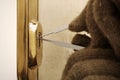 Detail of try to break into apartment with plastic lockpick blades Royalty Free Stock Photo
